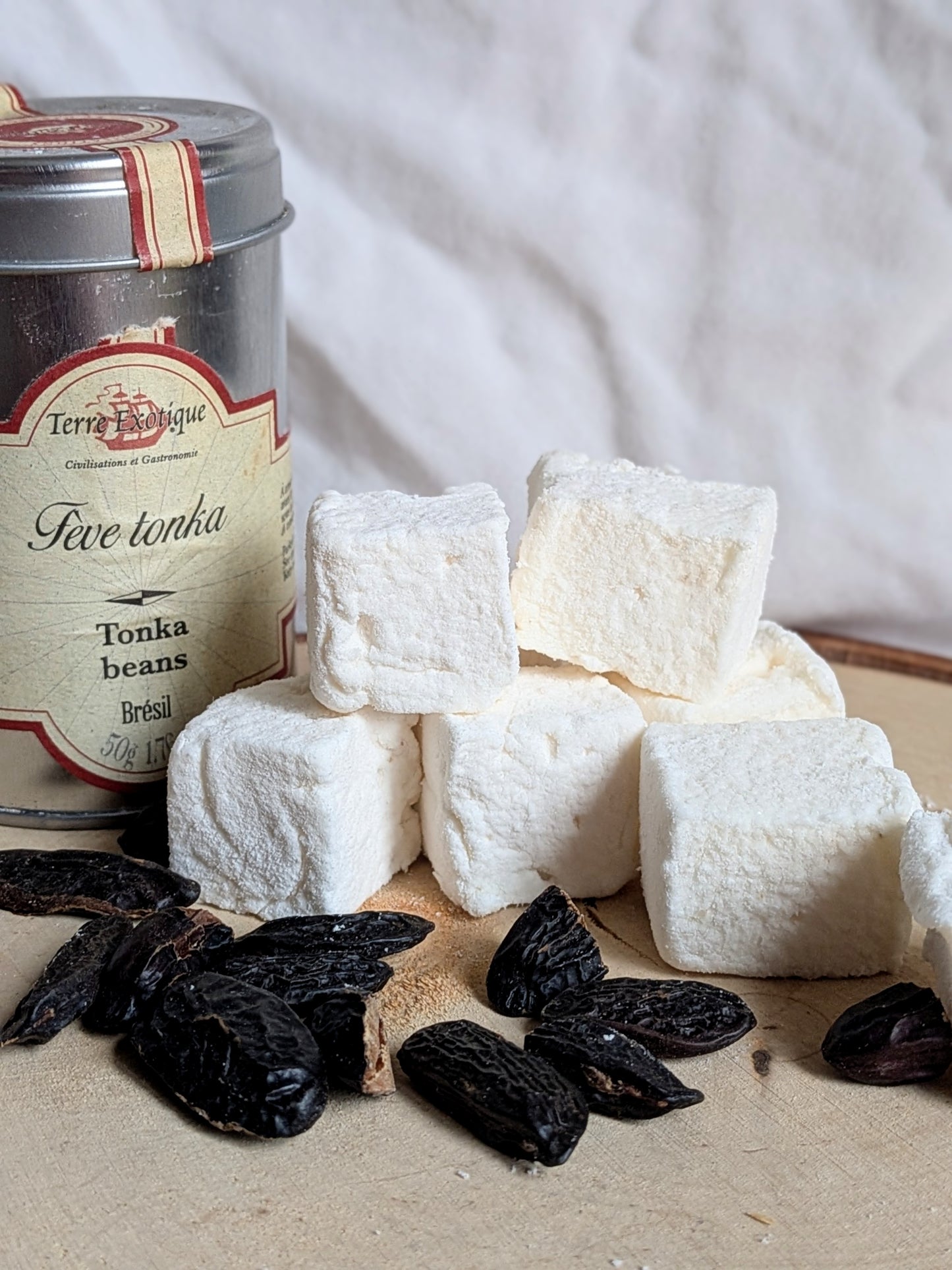 Gros plan sur la texture poudrée de guimauves artisanales à la fève tonka, révélant un aspect moelleux et nuageux, Les Tabliers Enchantés Orléans
