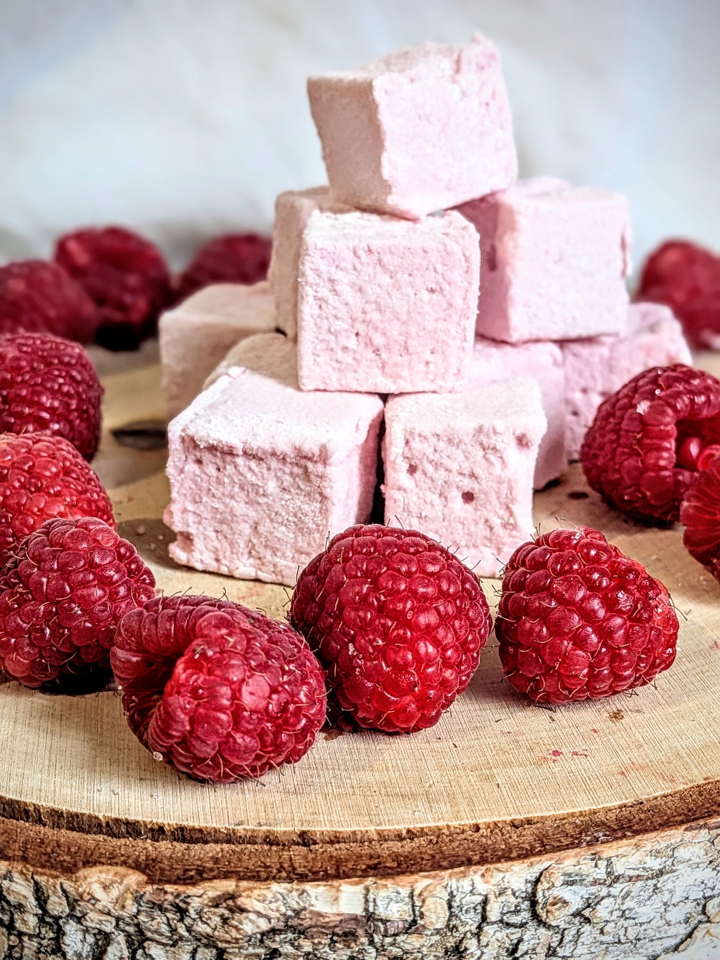 Guimauves artisanales ultra moelleuses à la framboise du Loiret, présentées sur un socle en bois
